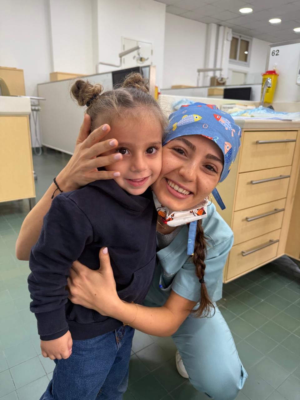Dr. Marilyn Nohra hugging a young patient at her pediatric dental clinic in Beirut